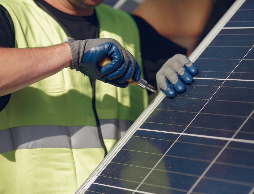 Engineer in a white helmet. Man near solar panel.